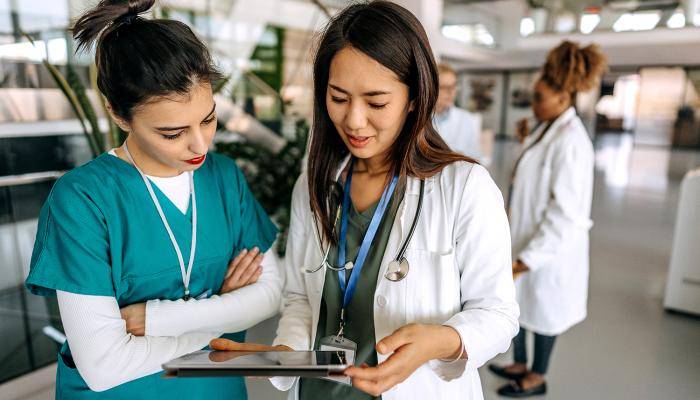 Medical professionals reviewing documents on Ipad