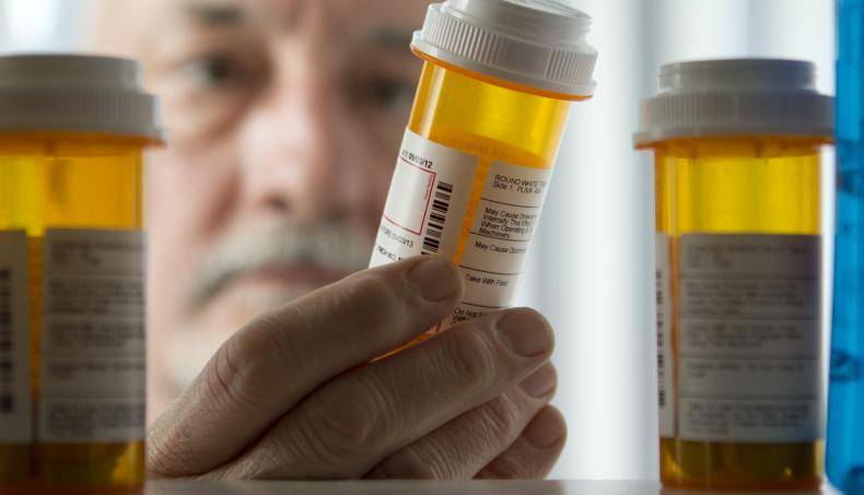 Man reading prescription bottle