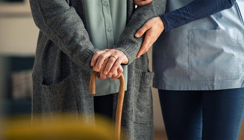 A nurse aiding a senior walk in order to prevent a fall