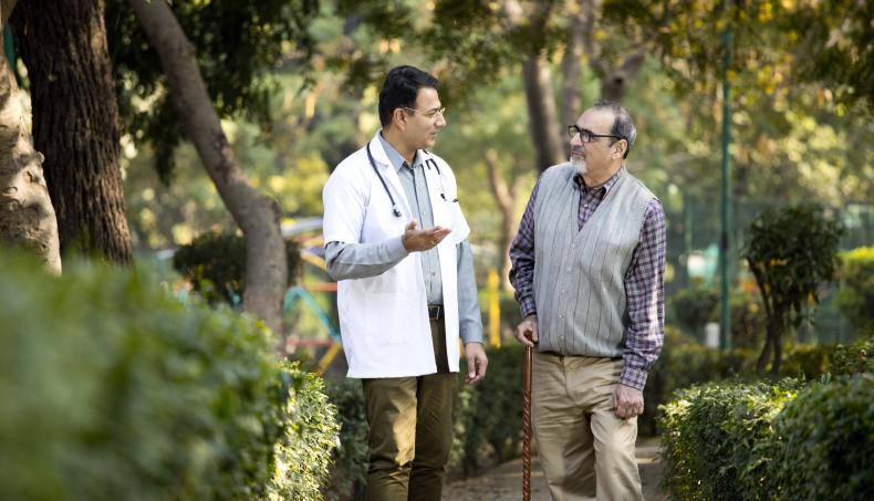Doctor with patient walking through park