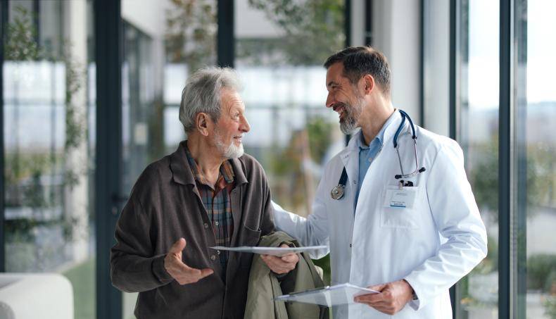 Doctor speaking to their senior patient as they walk together