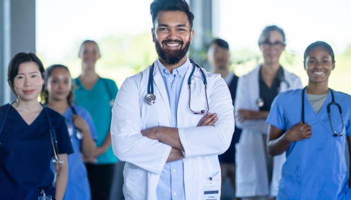 A group of doctors standing foward and smiling 