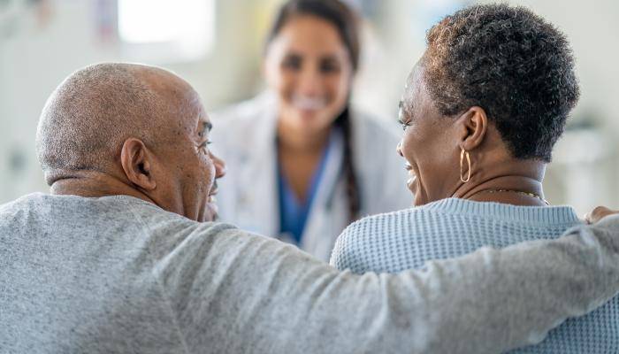 PCP speaking with senior patient and their family member about the importance of family support.