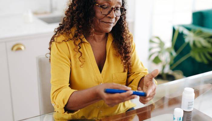 Senior using a glucose meter to monitor her glucose