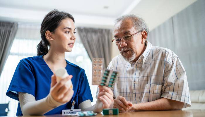 Nurse practitioner speaking with senior patient about medication adherence