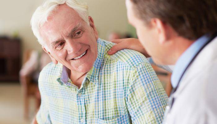 Physician reassuring a patient with a pat on the back