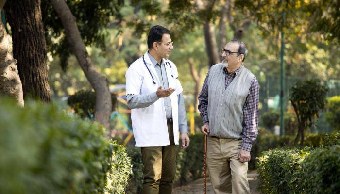 Doctor with patient walking through park