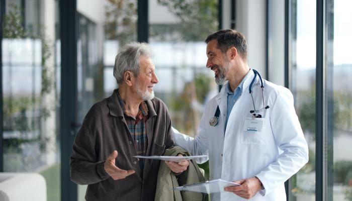 Doctor speaking to their senior patient as they walk together