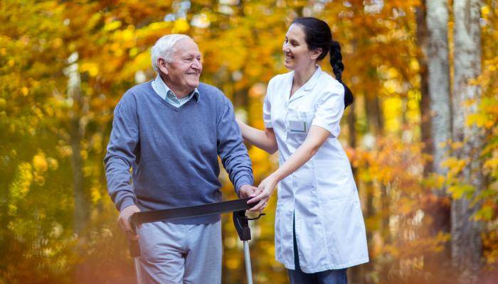 Physician walking with a patient outside in nature
